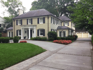 Long view of a house in cream color with plants around