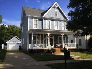 Front view of a house in blue color with american flag