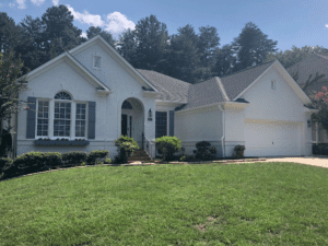 Front view of a house in white color with green grass