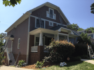 Side view of the house in brown color with plant in front