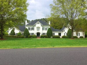 Long shot of a house surrounded by trees and grass