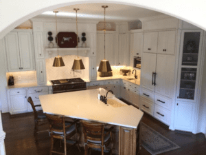 Dining and kitchen area of a house with three hanging lights