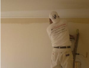 A man painting the interior wall of the house