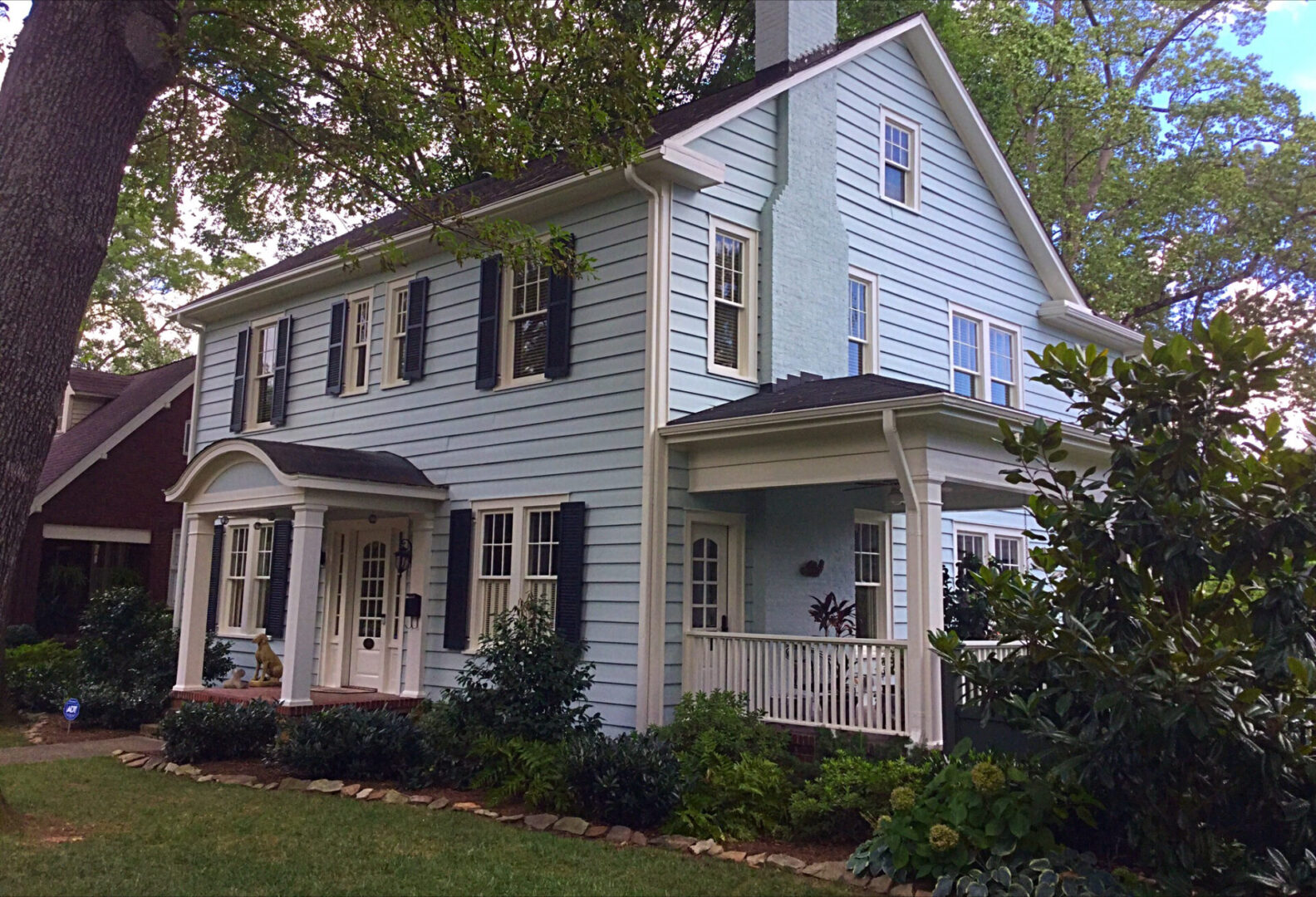 Blue house with white porch and yard.