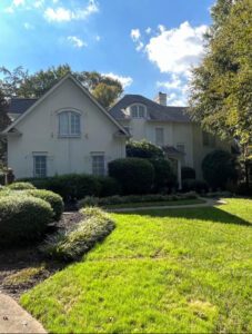 White two-story house with green lawn.