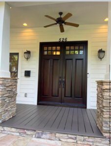 Front porch with wooden double doors.