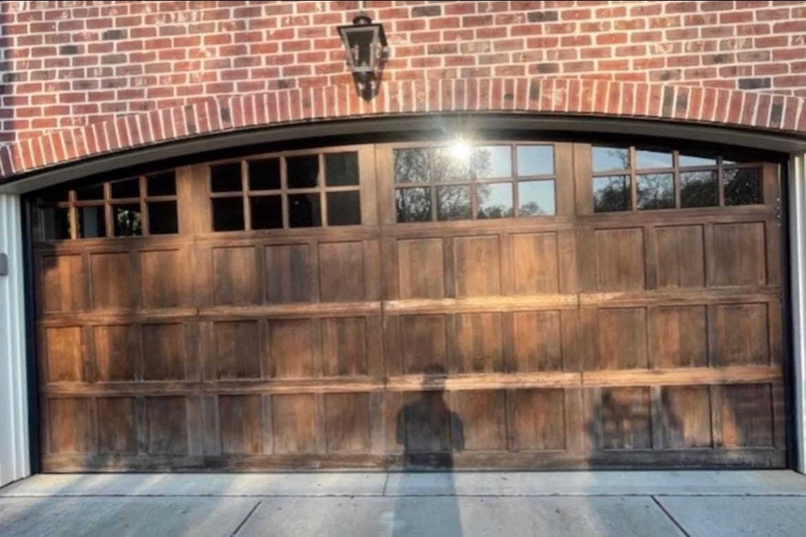 Weathered arched wood garage door with windows