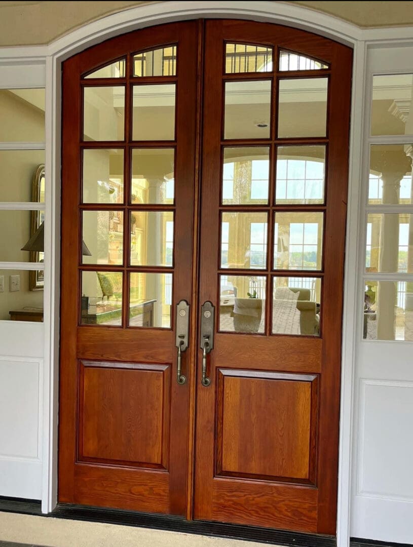Warm-toned arched double doors with glass panes
