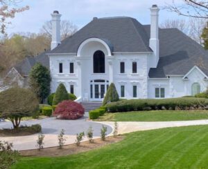 White mansion with a large lawn.