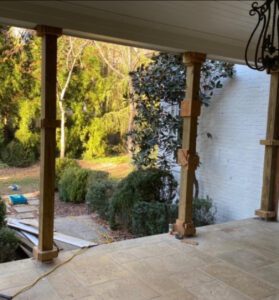 Wooden porch columns with view of trees.