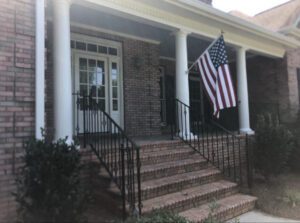 Brick house porch with American flag.