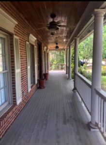 A brick house with a wooden porch.