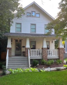 White two-story house with a front porch.