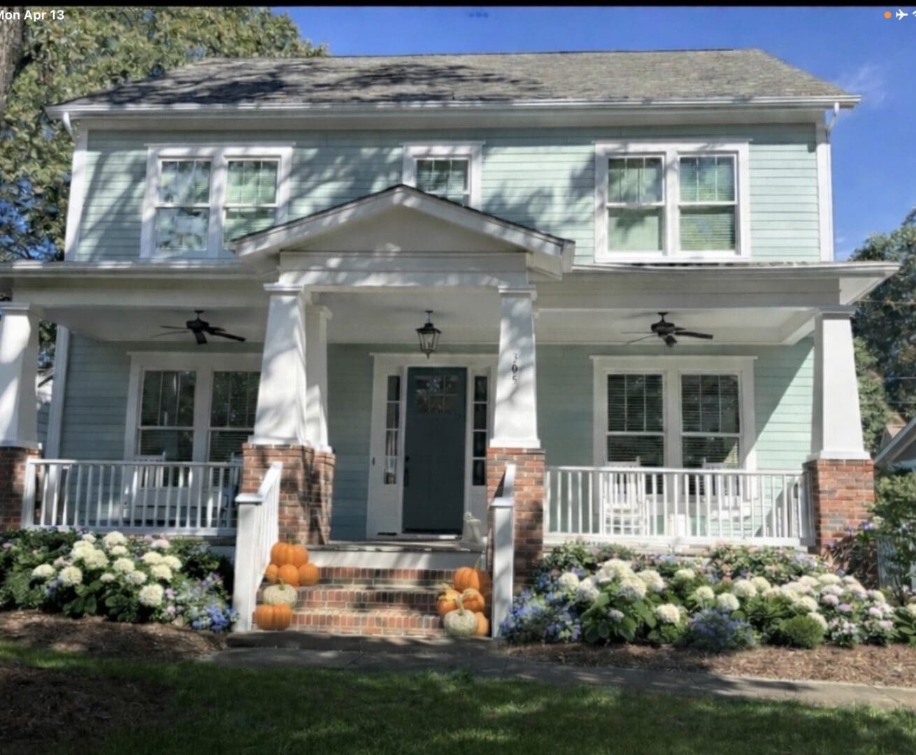 Blue house porch with pumpkins and hydrangeas