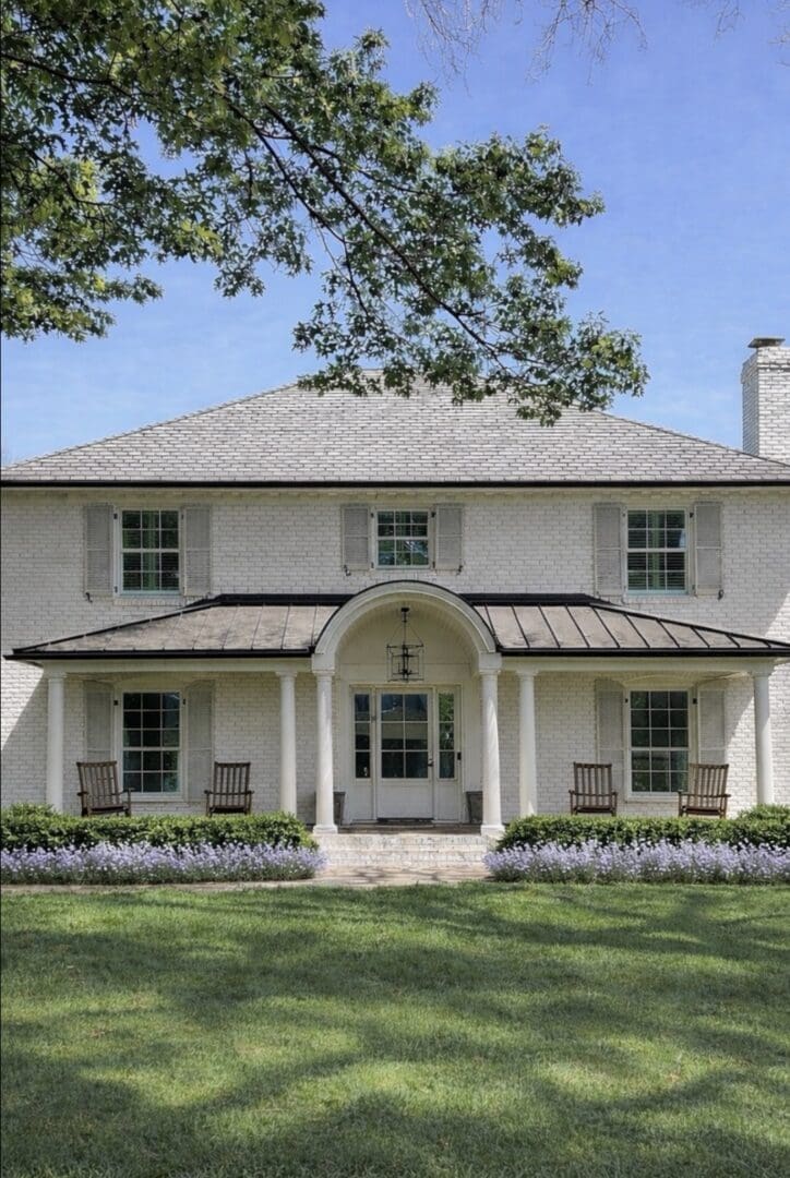 White two-story home with arched porch