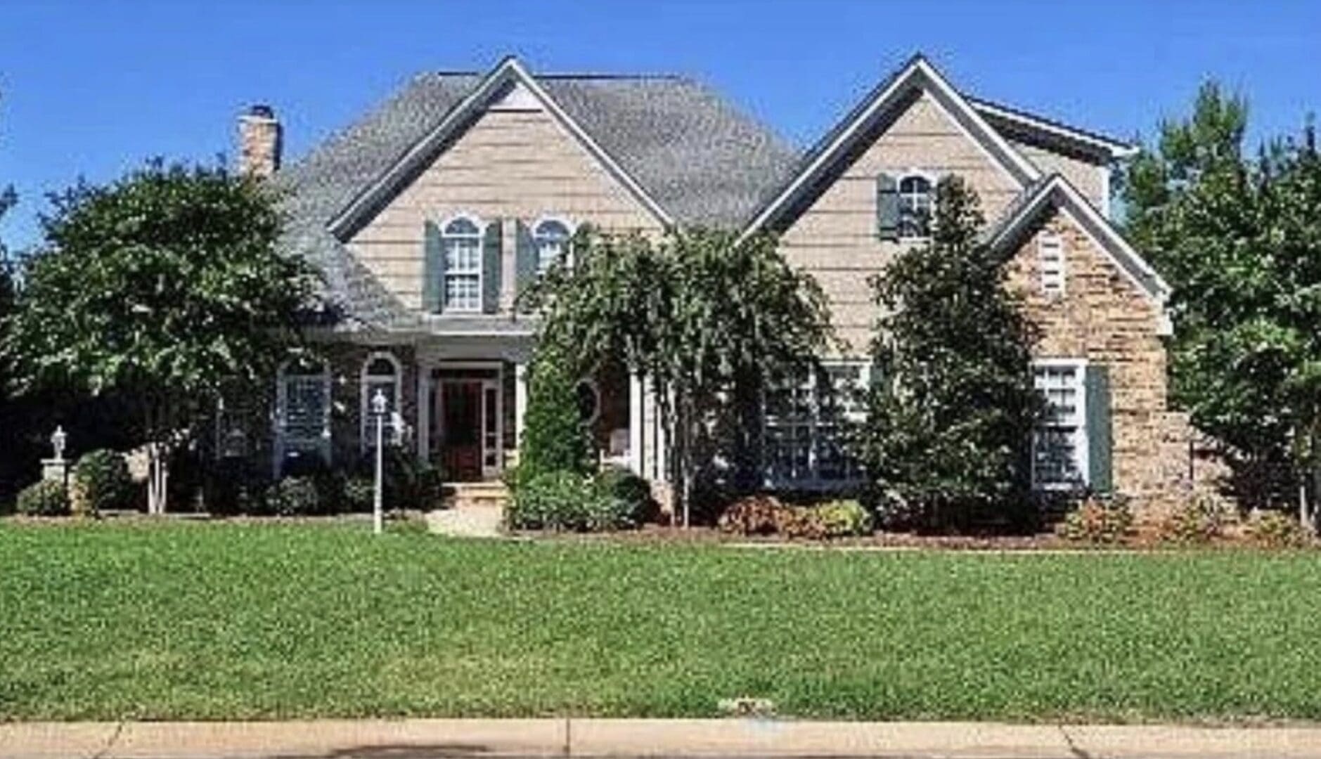 Two-story suburban home with manicured lawn