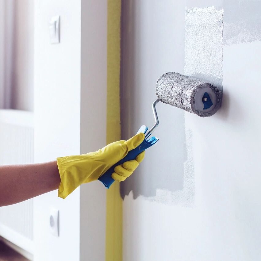 Hand painting a wall with a roller.